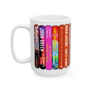 May include: White ceramic mug featuring a design of colorful book spines. Titles include "Book Lovers," "Daisy Jones & The Six," "A Court of Wings and Ruin," and "The Right Move." A perfect gift for book lovers.