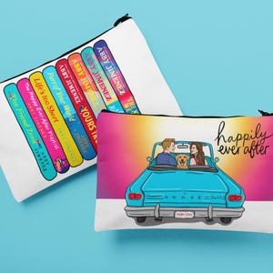 May include: Two white zippered pouches. One features a stack of colorful book spines with author Abby Jimenez's name. The other pouch has a couple in a blue car with a dog, and the words "happily ever after."