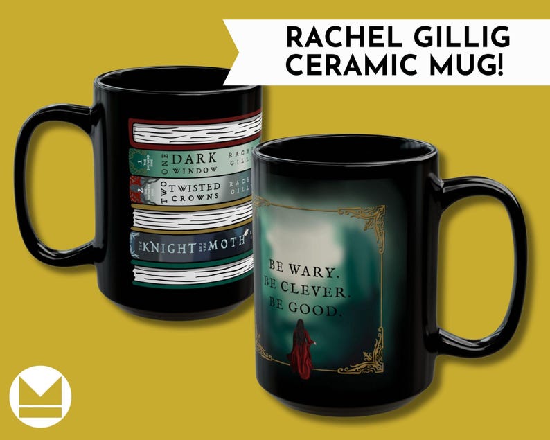 May include: Two black ceramic mugs. One mug features a stack of books with titles like "The Dark Window" and "Twisted Crowns." The other mug has the text "Be wary. Be clever. Be good." with a figure in a red cloak. The mugs are labeled "RACHEL GILLIG CERAMIC MUG!"