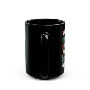 May include: Black ceramic mug with a large handle. The mug features a design of stacked books with text and colorful accents. The design is on the side of the mug, and the mug is set against a white background.