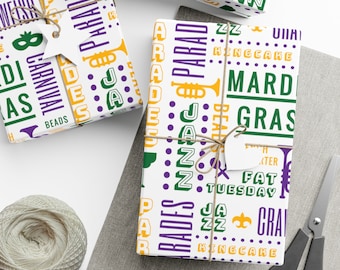 Puede incluir: Papel de regalo blanco con temática de Mardi Gras. El papel presenta un patrón repetitivo de texto e imágenes en verde, morado y dorado, incluyendo las palabras "Mardi Gras", "Jazz", "Parades", "King Cake" y "Fat Tuesday".