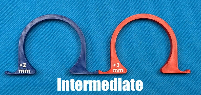 May include: Two arched, semi-circular tools, one blue and one orange, with measurements of +2 mm and +3 mm, respectively. The word "Intermediate" is printed in white below the tools. The tools are on a blue background.