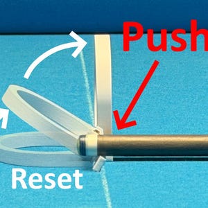 May include: Image showing a pool cue with a white and clear plastic device attached. The word "Push" is written in red, with a red arrow pointing towards the cue. The word "Reset" is written in white.