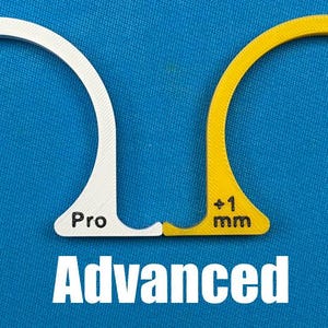 May include: Two arched, semi-circular tools, one white and one yellow, with a blue background. The white tool has the text "+1/2 mm" and "Pro". The yellow tool has the text "+1 mm". The word "Advanced" is below.