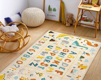 May include: A cream-colored play rug with a colorful alphabet, numbers, and dinosaur illustrations. The rug features a yellow, blue, and green color scheme.