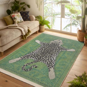 May include: A green rug with a large, black and white leopard print design. The leopard is lying on its back with its paws outstretched. The rug has a paisley pattern around the edges.