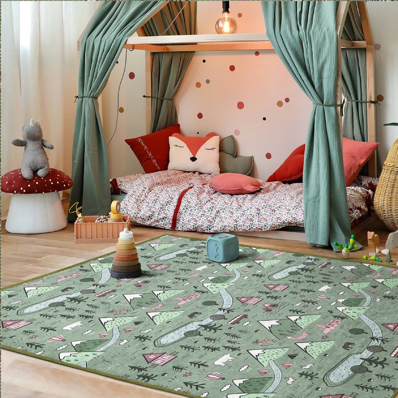 May include: A green and white play mat with a woodland theme. The mat features mountains, trees, animals, and houses. The mat is perfect for a child's playroom or bedroom.