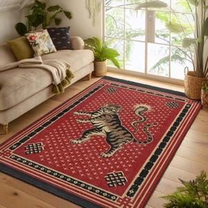 May include: Red and black area rug with a detailed design featuring a tiger and a snake. The rug has a traditional pattern with intricate details.