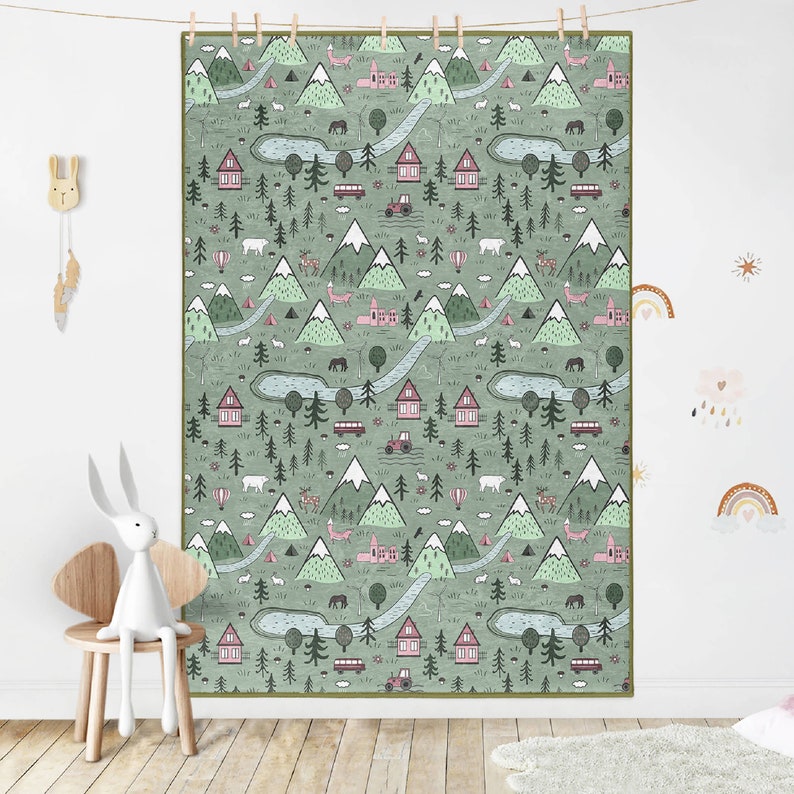 May include: A green and pink patterned rug with a repeating design of mountains, trees, houses, and a river. The rug has a white background and is perfect for a child's room.