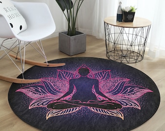 Pode incluir: Um tapete redondo preto e roxo com um design de mandala rosa e branco que apresenta uma figura meditando no centro.