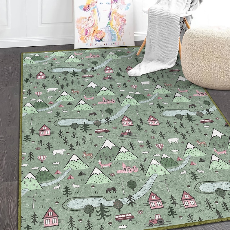 May include: A green and pink patterned rug with a whimsical design featuring mountains, trees, houses, and animals. The rug has a green border.