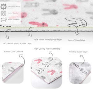 May include: A gray and pink area rug with a bunny rabbit pattern. The rug has a non-slip rubber backing and is machine washable. It is also robot vacuum friendly and pet and kid friendly.