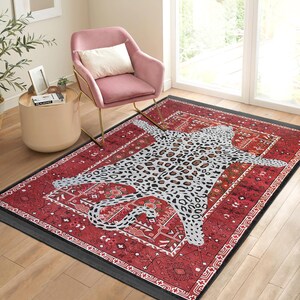 May include: A red and black area rug with a white and gray leopard print design. The rug has a traditional pattern with intricate details.