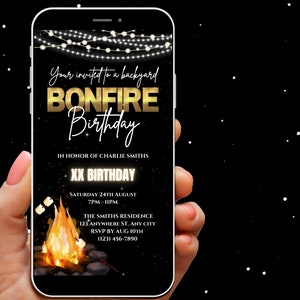 Könnte beinhalten: Ein schwarzer und goldener Smartphone-Bildschirm zeigt eine Geburtstagseinladung für eine Feuerstellen-Geburtstagsfeier. Die Einladung zeigt ein Lagerfeuer mit Marshmallows, Lichterketten und den Text "Your invited to a backyard Bonfire Birthday" in goldenen Buchstaben. Die Einladung enthält auch den Text "In honor of Charlie Smiths XX Birthday" und Details zur Veranstaltung, einschließlich Datum, Uhrzeit, Ort und RSVP-Informationen.