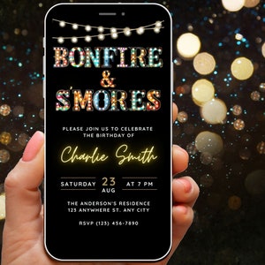 Pode incluir: Um smartphone exibe um convite digital para uma festa de aniversário com fogueira e s'mores. O convite apresenta o texto "BONFIRE & S'MORES" em letras coloridas estilo marquise, com detalhes do evento e o nome "Charlie Smith".