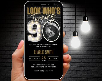 Puede incluir: Una pantalla de teléfono inteligente negra y dorada que muestra una invitación a una fiesta de cumpleaños para un 90 cumpleaños. La invitación presenta una foto de una persona, el texto "LOOK WHO'S Turning 90" y detalles sobre la fiesta, incluida la fecha, la hora y la ubicación.