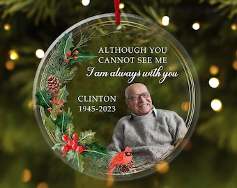May include: A clear glass Christmas ornament with a gold rim and a watercolor design of holly, berries, and a cardinal. The ornament features a photo of a man and the text "Although you cannot see me I am always with you Clinton 1945-2023".
