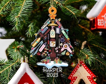 May include: A Christmas tree ornament shaped like a tree, filled with hair styling tools. The ornament has a gold chain and a star at the top. The name "HARPER" and the year "2023" are printed on the bottom.
