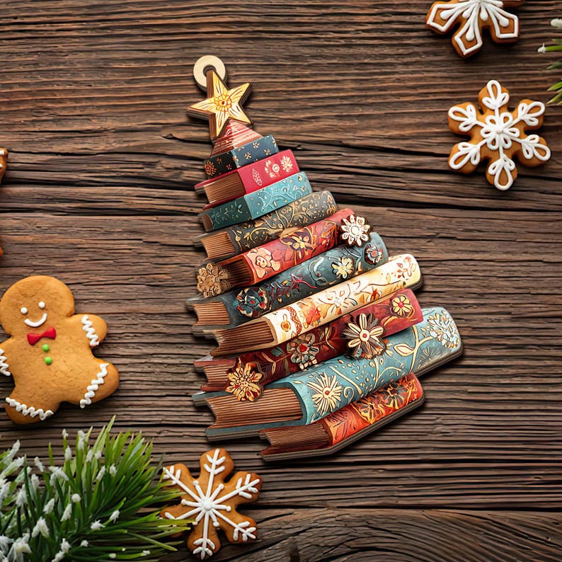K&ouml;nnte beinhalten: Ein Weihnachtsbaum-Dekoration aus gestapelten, farbenfrohen B&uuml;chern mit floralen Designs. Ein goldener Stern ziert die Spitze. Lebkuchen und ein Schneeflocken-Keks sind auf einer Holzoberfl&auml;che verstreut.
