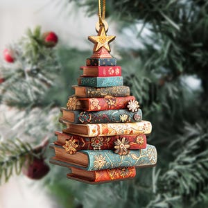 K&ouml;nnte beinhalten: Weihnachtsbaumschmuck in Form eines B&uuml;cherstapels. Der Ornament ist aus Holz gefertigt und hat einen goldenen Stern an der Spitze. Die B&uuml;cher sind in verschiedenen Farben wie Rot, Blau und Braun gehalten und mit floralen Mustern verziert.