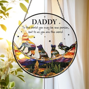 May include: Circular stained glass window art with the word "DADDY" at the top. The artwork features a wolf and three dogs, with names below them. The text reads "To the world you may be one person, but to us you are the world."