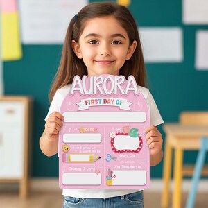 May include: A pink first day of school sign with the name "AURORA" at the top. The sign has spaces to fill in details like date, age, teacher's name, and things the child loves. Decorative elements include apples, a pencil, and scissors.