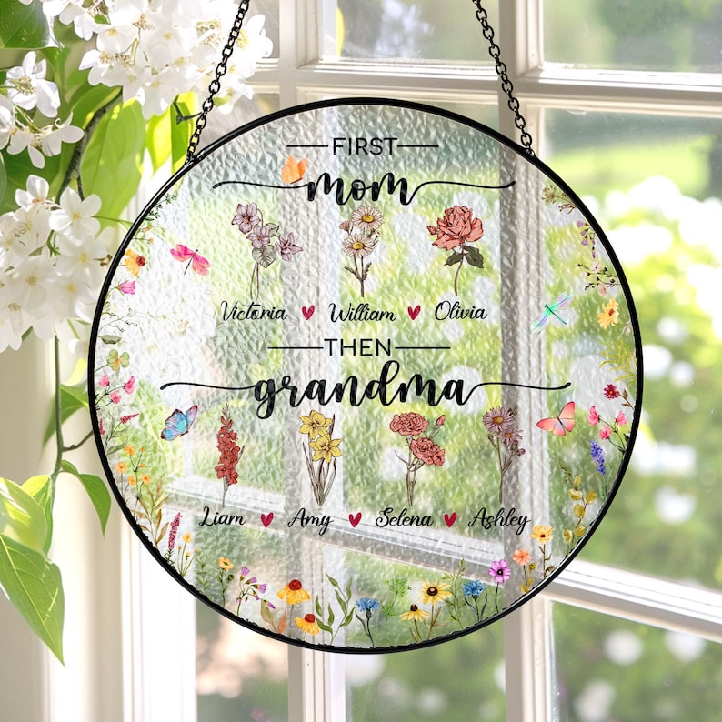 May include: Round glass suncatcher with a floral design and the text "First Mom Then Grandma" with names of children listed below.