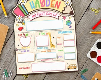 May include: Wooden 'My First Day Of' sign with the name 'Hayden' in colorful letters. The sign includes spaces to write personal information, such as age, height, favorites, and teacher's name. Decorated with school-themed illustrations.