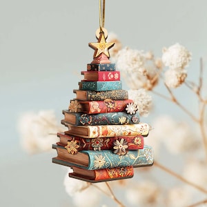 K&ouml;nnte beinhalten: Ein Weihnachtsbaumschmuck aus Holz in Form eines B&uuml;cherstapels. Die B&uuml;cher sind in verschiedenen Farben gehalten, darunter Rot, Blau und Braun, mit Blumen- und Sternmustern. Ein Holzstern sitzt oben, mit einem goldenen Faden zum Aufh&auml;ngen.