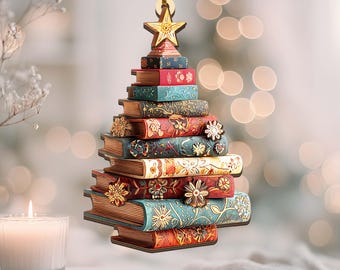 May include: A Christmas tree ornament shaped like a stack of books. The books are various colors, including red, blue, and gold, and are decorated with floral patterns. A gold star tops the tree, and a gold string is attached for hanging.