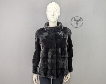 本物のミンクの毛皮を使用した黒のコート。ストリートスタイルに