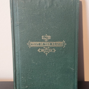 May include: A vintage hardcover book titled "The Tent on the Beach" by Whittier. The cover is a deep green with gold lettering and decorative elements. The book appears to be well-preserved, with a slightly worn appearance.