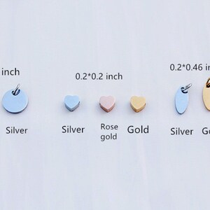 May include: A collection of small metal charms in rose gold, silver, and gold. Shapes include circles, hearts, and ovals. Sizes range from 0.2 x 0.2 inches to 0.4 x 0.4 inches. Each charm has a small loop for attaching to jewelry.
