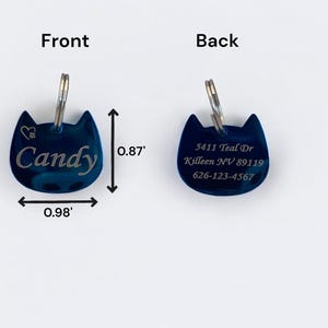 May include: A dark blue cat-shaped metal pet ID tag with a silver split ring. The front features the name Candy and a heart icon. The back displays the address 5411 Teal Dr, Killeen NV 89119 and phone number 626-123-4567. Dimensions are 0.98 inches by 0.87 inches.
