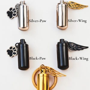 May include: Image features several small, cylindrical urns in silver, black, and gold. Some have paw print or wing charms. Text reads "Choose Your Style" with options like "Silver+Paw" and "Golden+Wing or Paw."
