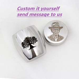 May include: Two stainless steel containers. One is a tumbler with a black tree design. The other is a round container with an engraved portrait of a man wearing a hat. The text "Custom it yourself send message to us" is above the containers.
