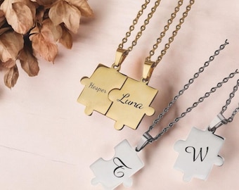 May include: Three gold and silver puzzle piece necklaces with the names "Hesper" and "Luna" engraved on the gold pieces and the letters "E" and "W" engraved on the silver pieces.
