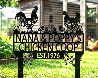 May include: Black metal chicken coop sign with the text "NANA & POPPY'S CHICKEN COOP EST.1976". The sign features silhouettes of a rooster, hen, chicks, and a nest. The sign is displayed in a grassy yard with a chicken coop in the background.