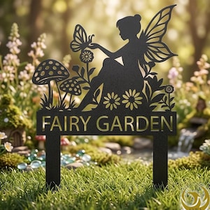 Puede incluir: Letrero de jardín de hadas de metal negro con una hada con mariposa, flores y setas. El letrero dice "FAIRY GARDEN" en letras doradas. El letrero está diseñado para ser colocado en un jardín.