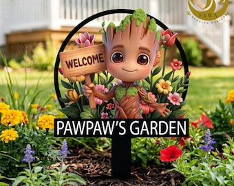 May include: A garden stake featuring a cartoon character holding a "WELCOME" sign, surrounded by colorful flowers. The stake reads "PAWPAW'S GARDEN" in white text. The character has a tree-like appearance with a friendly expression.