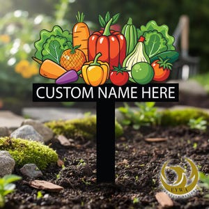 May include: A black metal garden stake featuring a colorful assortment of illustrated vegetables, including carrots, peppers, tomatoes, and lettuce. The stake has the text "CUSTOM NAME HERE" and is designed for personalized garden use.