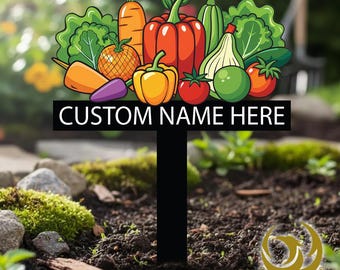 May include: A black metal garden stake featuring a colorful assortment of illustrated vegetables, including carrots, peppers, tomatoes, and lettuce. The stake has the text "CUSTOM NAME HERE" and is designed for personalized garden use.