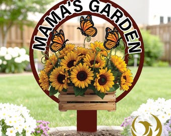 May include: A metal garden sign with the text "MAMA'S GARDEN" in a circular design. The sign features a wooden crate filled with sunflowers and orange butterflies. The sign is mounted on a red stake.
