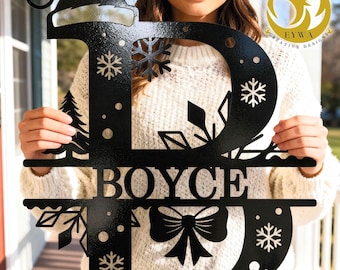 May include: Black metal Christmas-themed sign in the shape of the letter "D" with the name "BOYCE" and snowflake and tree cutouts. The top of the "D" has a Santa hat design. The sign is held by a person.