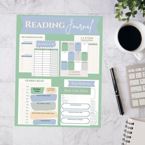 以下が含まれることがあります： 水色と緑のデザインの読書ジャーナル。ジャーナルには、おすすめ、読書記録、A-Zの著者チャレンジ、読んだジャンル、本の振り返り、ブッククラブのメモのセクションが含まれています。コーヒーカップ、ペン、キーボードも表示されています。