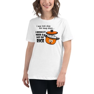 Puede incluir: Camiseta blanca con el texto "I may look okay, But deep down... I REALLY NEED A POT OF RICE." El gráfico presenta una olla de arroz de dibujos animados naranja con una cara. La camiseta es de corte holgado.