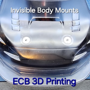 May include: A close-up of a white plastic car body with two visible body mounts. The text "Invisible Body Mounts" is printed on the top of the body. The text "ECB 3D Printing" is printed on the bottom of the body.