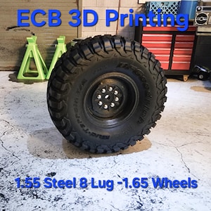 Puede incluir: Una rueda de acero negra de 1,55 pulgadas con 8 pernos y un neumático de 1,65 pulgadas. La rueda está sobre un suelo de hormigón con el texto "ECB 3D Printing" encima.