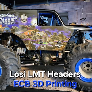 以下が含まれることがあります： 大きなタイヤと青いアクセントが特徴のカスタムモンスタートラック。トラックにはスカルグラフィックと「Grave Digger」の文字が描かれています。下部のテキストは「Losi LMT Headers ECB 3D Printing」と書かれています。
