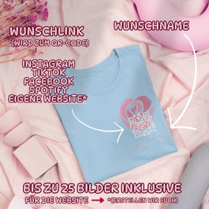 May include: A light blue t-shirt with a pink rose and QR code design. The shirt has text that says "Mutin & Mar". Additional text includes "Instagram, TikTok, Facebook, Spotify, Eigene Website".